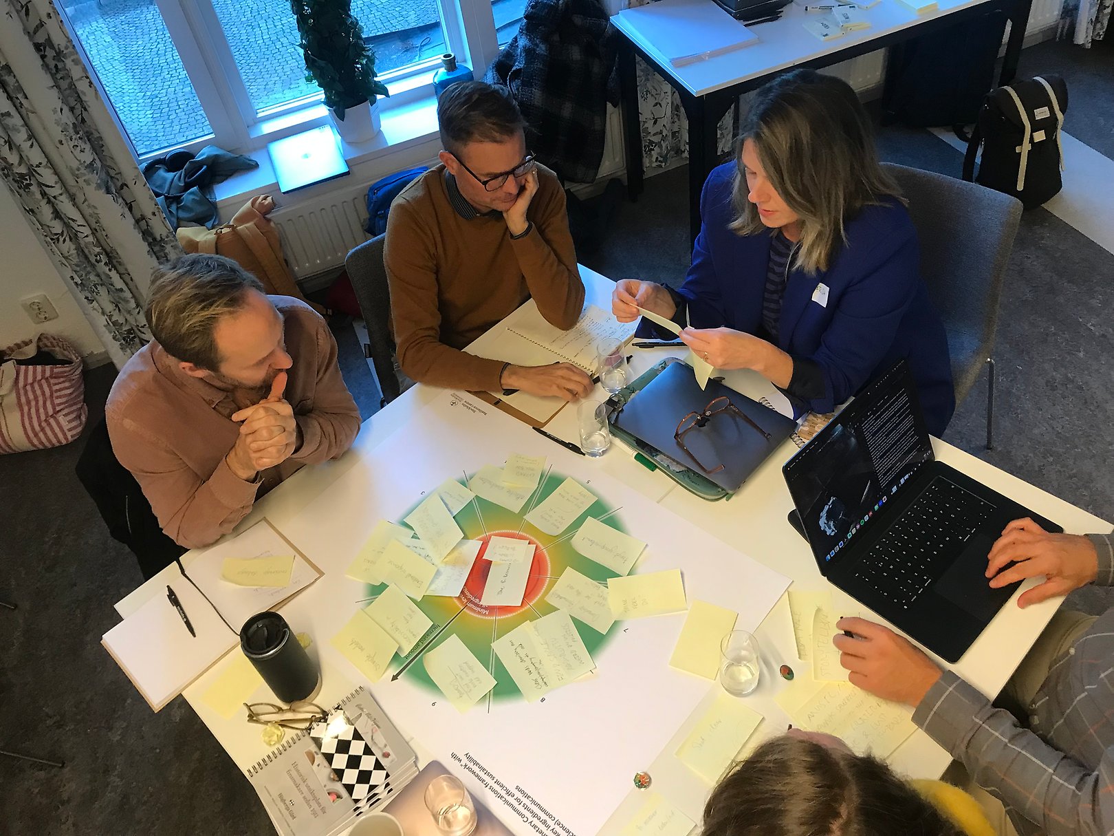 People sitting around a table discussing planetary communications figure